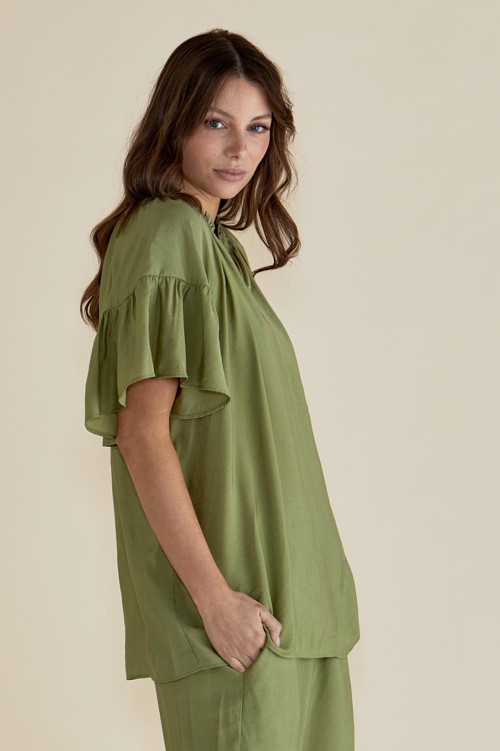 A model wearing the Vivienne Blouse in colour Pistachio (Green), from the front, cropped image