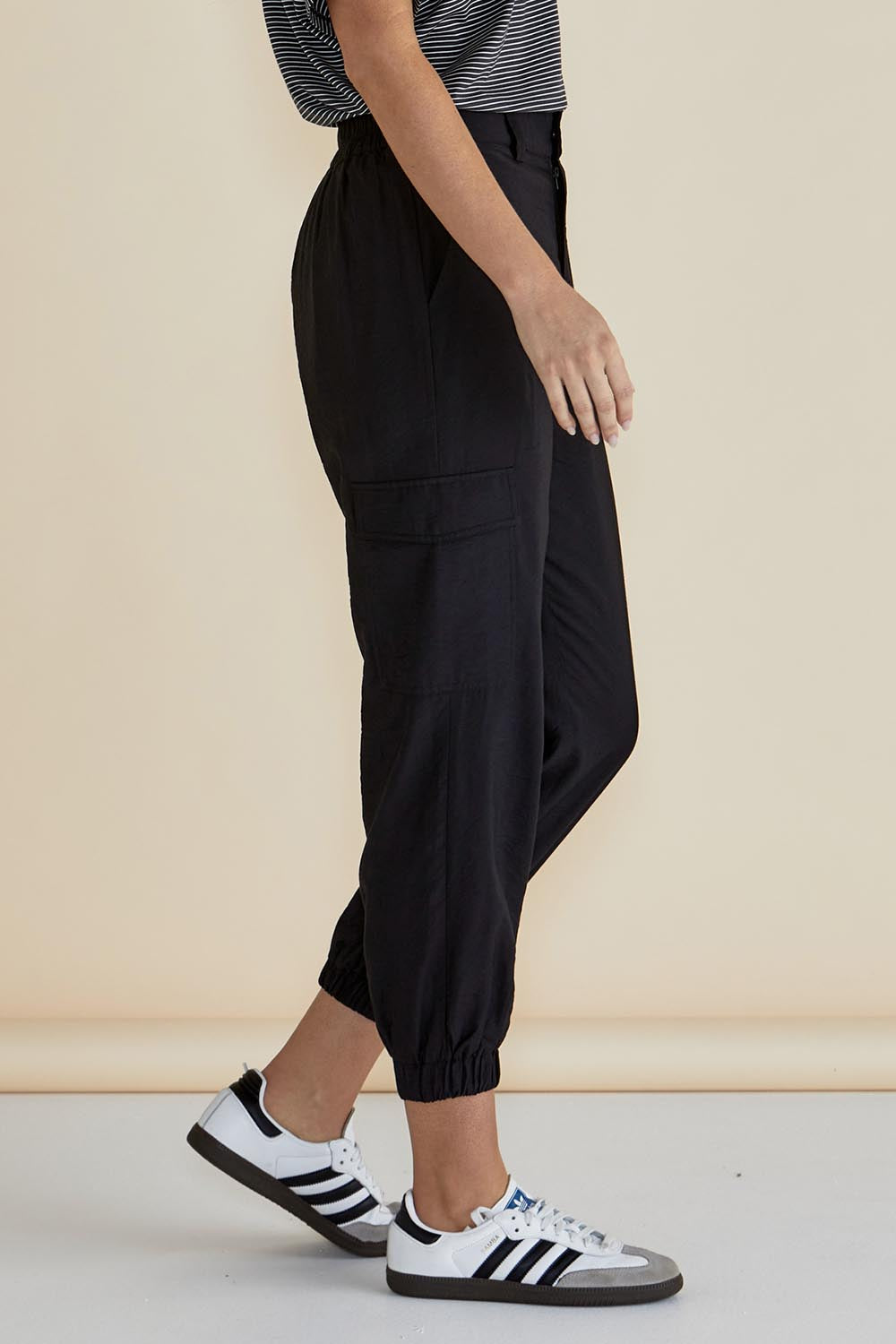 A model wearing the Adrianna Jogger in colour Black (Black), from the front, cropped image