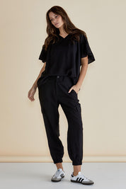 A model wearing the Adrianna Jogger in colour Black (Black), from the front, showing the whole outfit