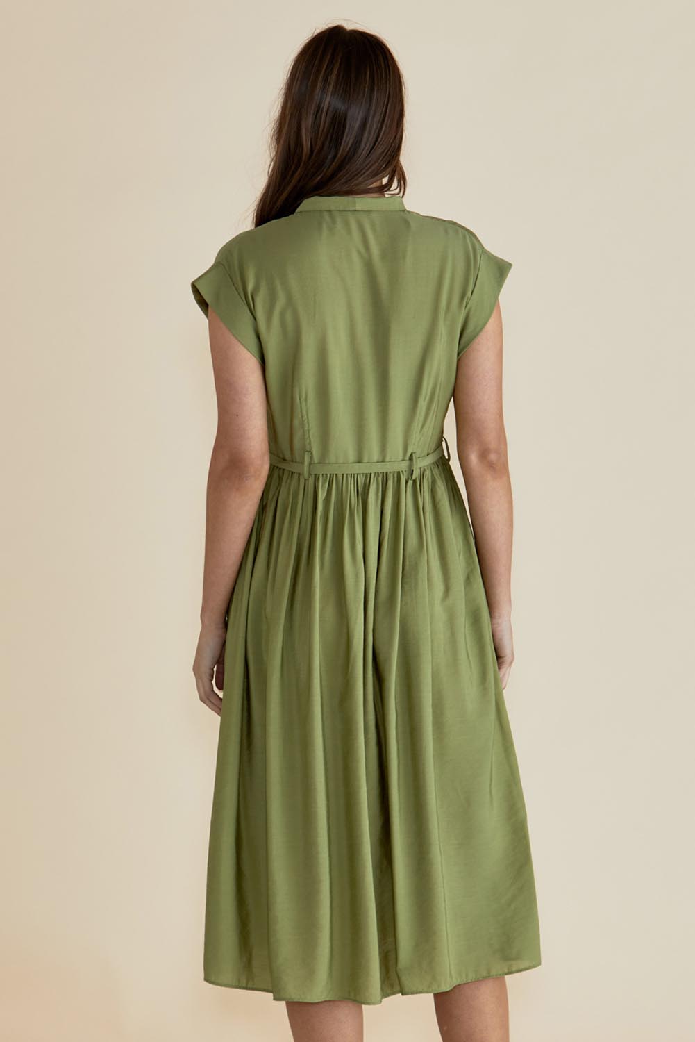 A model wearing the Elianna Dress in colour Pistachio (Green), from the back