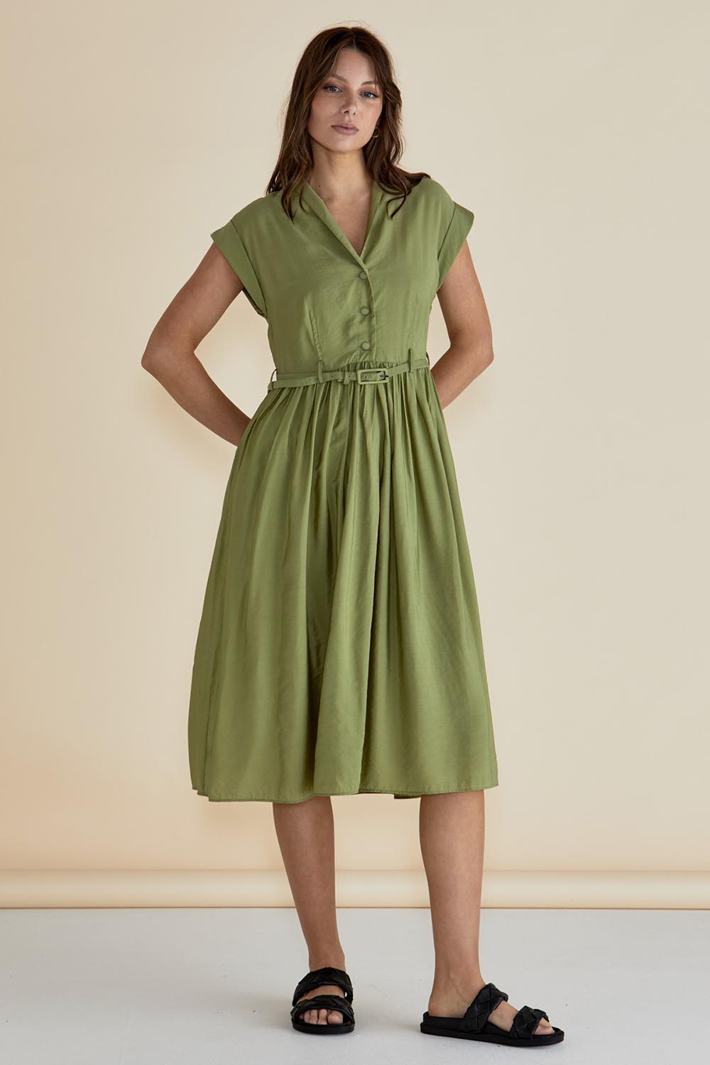 A model wearing the Elianna Dress in colour Pistachio (Green), from the front, showing the whole outfit