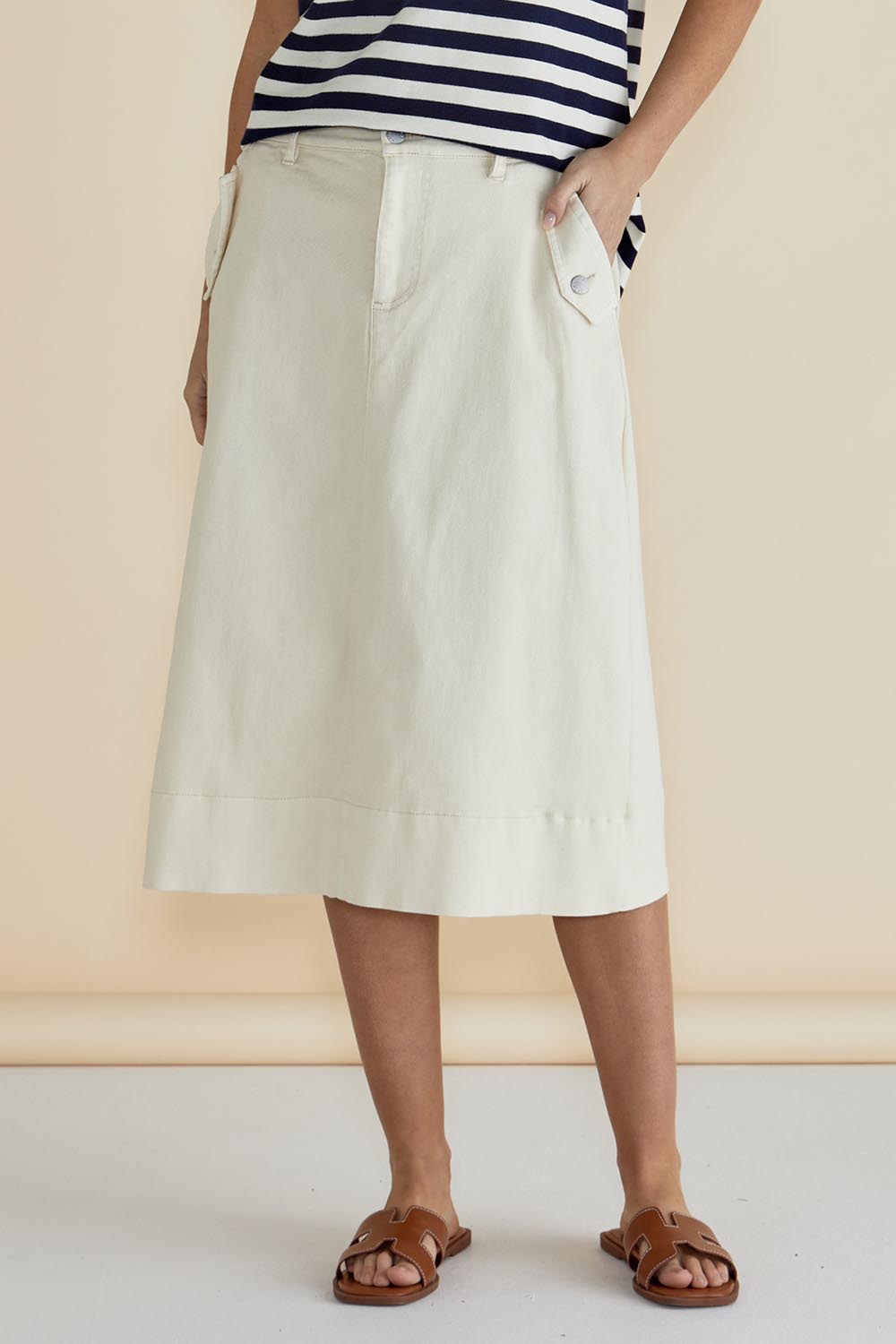 A model wearing the Astra Denim Skirt in colour Offwhite (White), from the front, cropped image