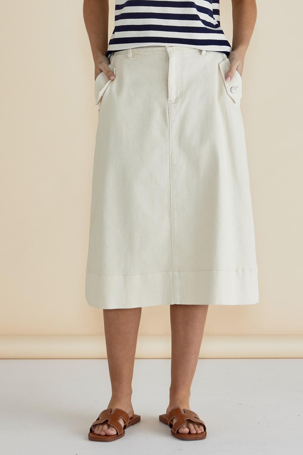 A model wearing the Astra Denim Skirt in colour Offwhite (White), from the front, cropped image