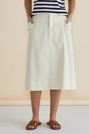 A model wearing the Astra Denim Skirt in colour Offwhite (White), from the front, cropped image