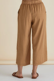 A model wearing the Rio Lyocell Relaxed Pant in colour Tan, from the back