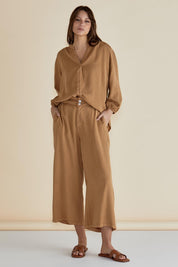 A model wearing the Rio Lyocell Relaxed Pant in colour Tan, from the front, showing the whole outfit