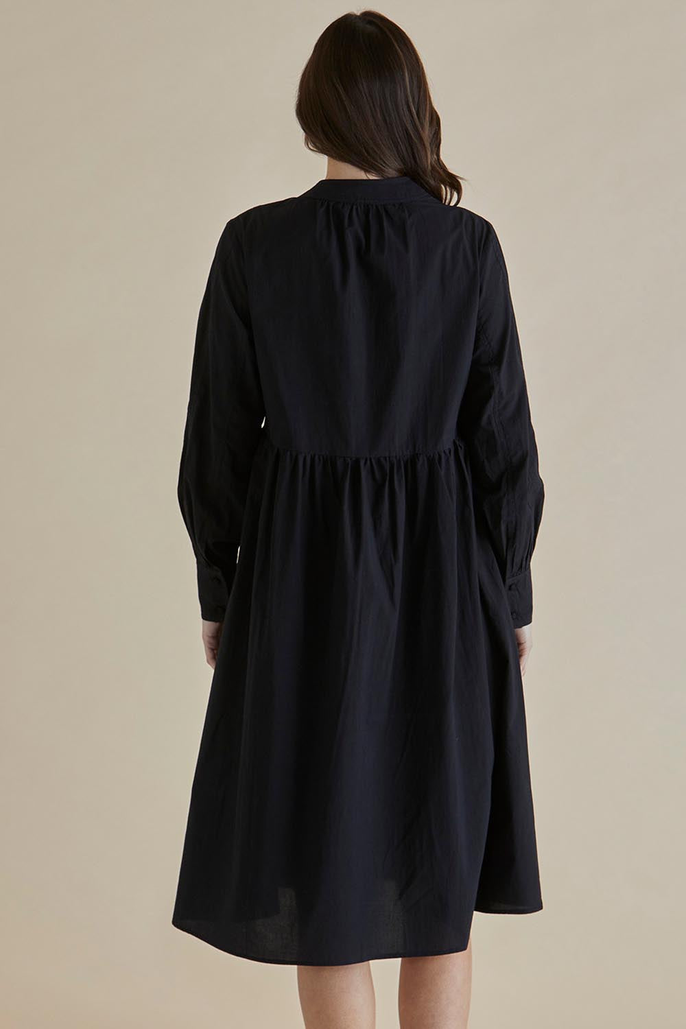 A model wearing the Chardonnay Cotton Dress in colour Black (Black), from the back