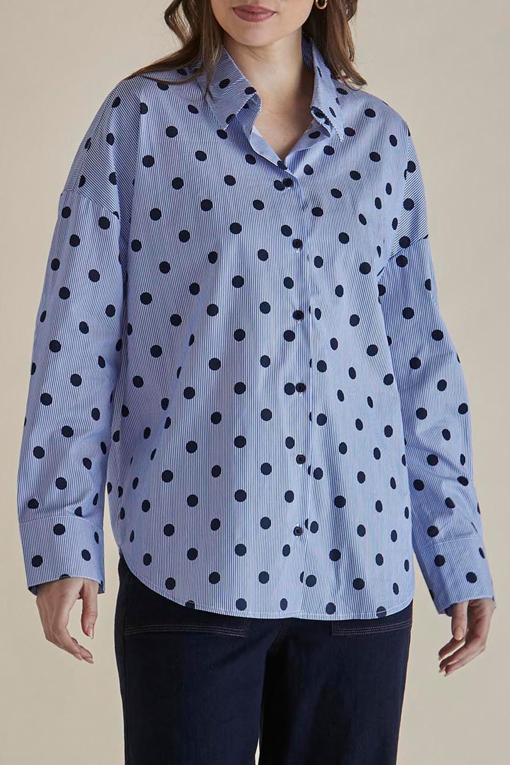 A model wearing the Sage Cotton Shirt in colour Polkadot (Blue), from the front, cropped image