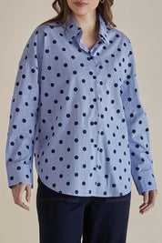 A model wearing the Sage Cotton Shirt in colour Polkadot (Blue), from the front, cropped image
