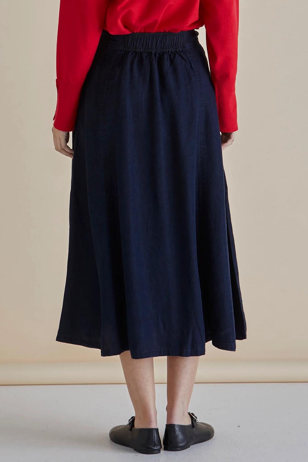 A model wearing the Lola Lyocell Skirt in colour Drkvintage (Blue), from the back