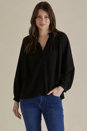 A model wearing the Marie Blouse in colour Black (Black), from the front, cropped image