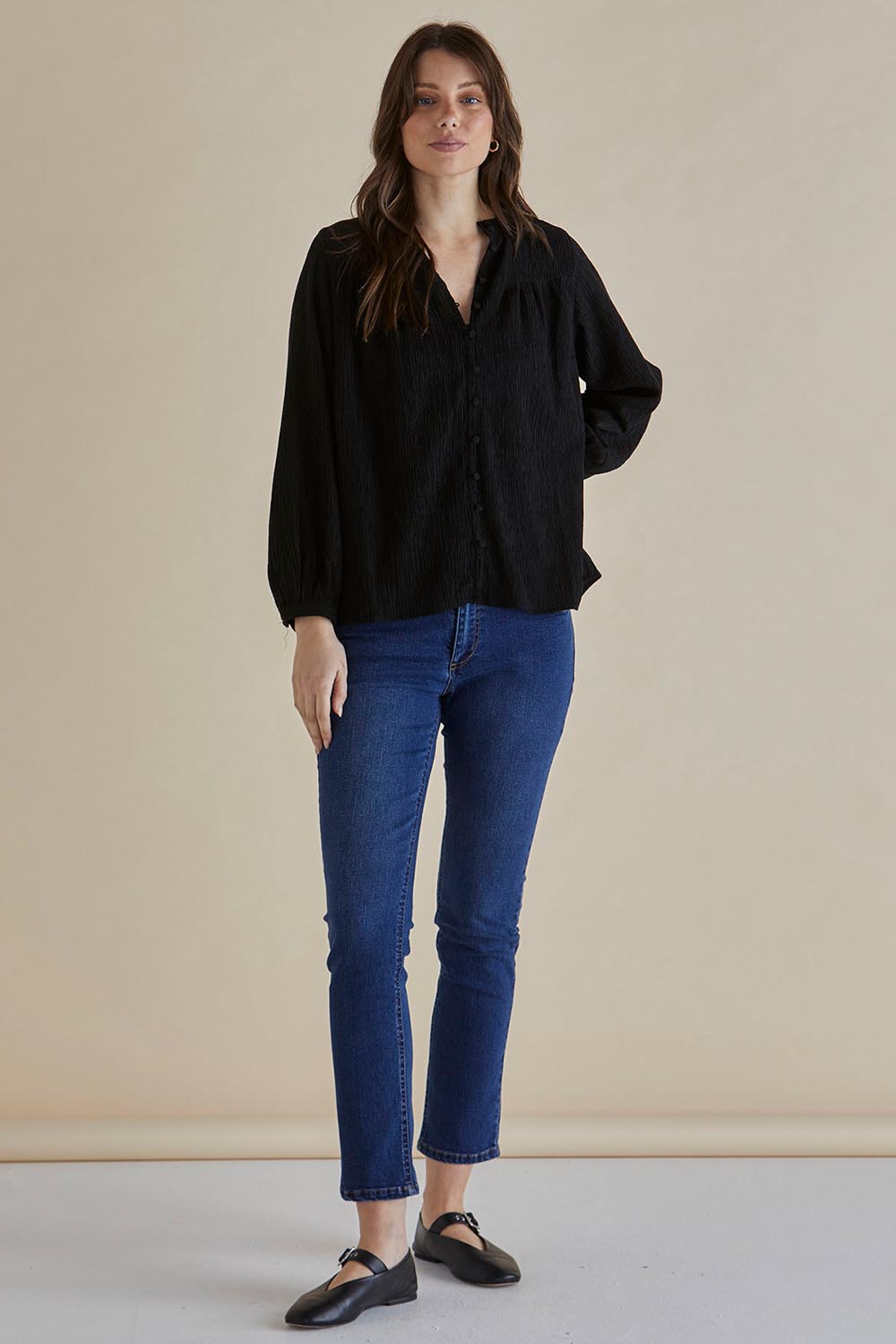 A model wearing the Marie Blouse in colour Black (Black), from the front, showing the whole outfit