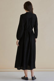 A model wearing the Anette Dress in colour Black (Black), from the back