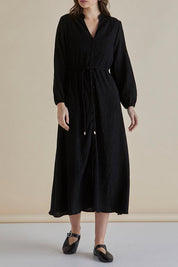 A model wearing the Anette Dress in colour Black (Black), from the front, cropped image