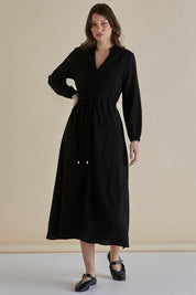 A model wearing the Anette Dress in colour Black (Black), from the front, showing the whole outfit