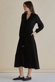A model wearing the Anette Dress in colour Black (Black), from the front, showing the whole outfit