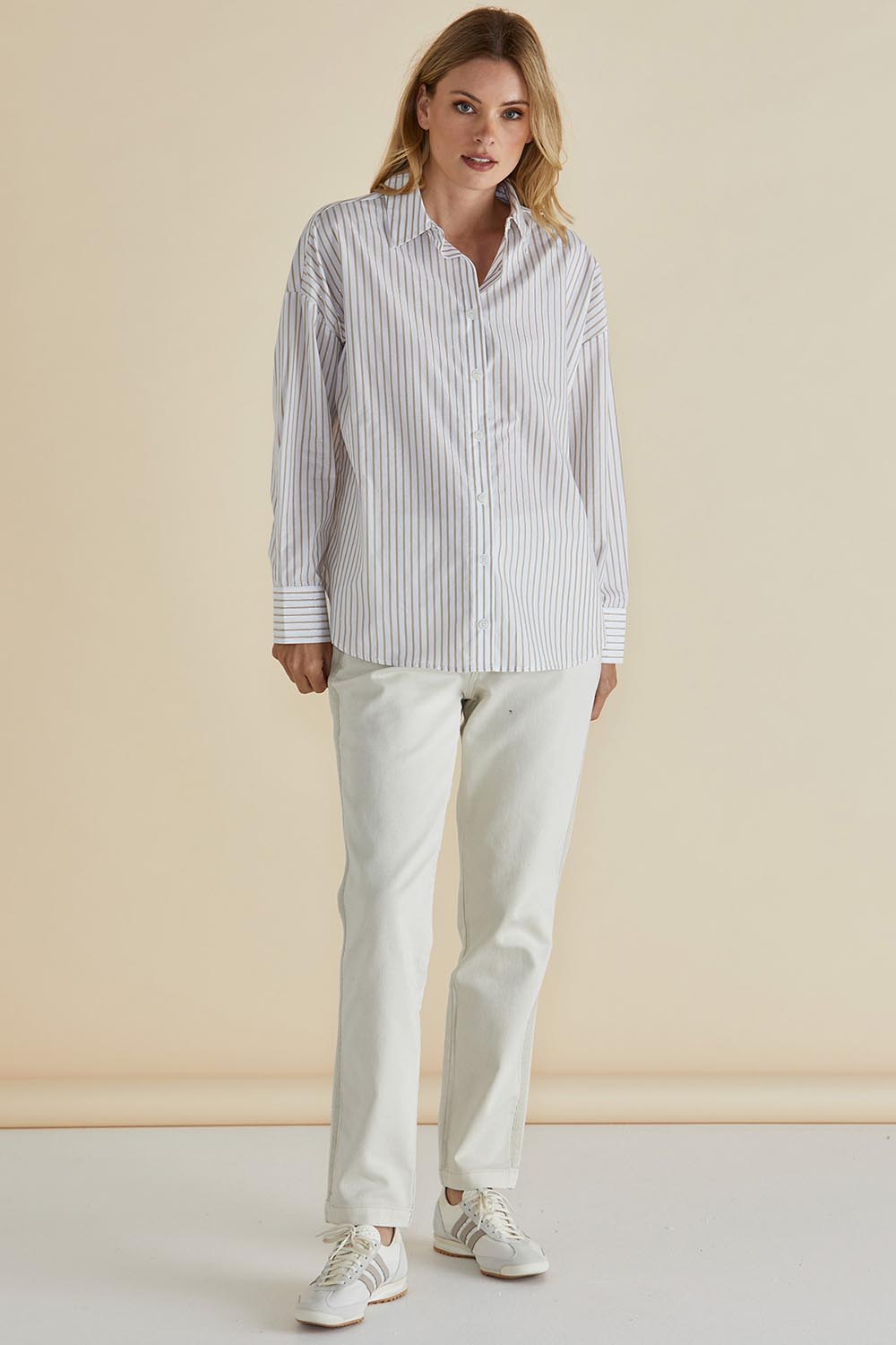 A model wearing the Artemis Cotton Shirt in colour Beigelurex, from the front, showing the whole outfit