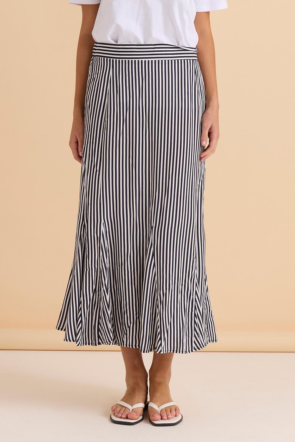 A model wearing the Darla Skirt in colour Navystripe (Blue), from the front, cropped image