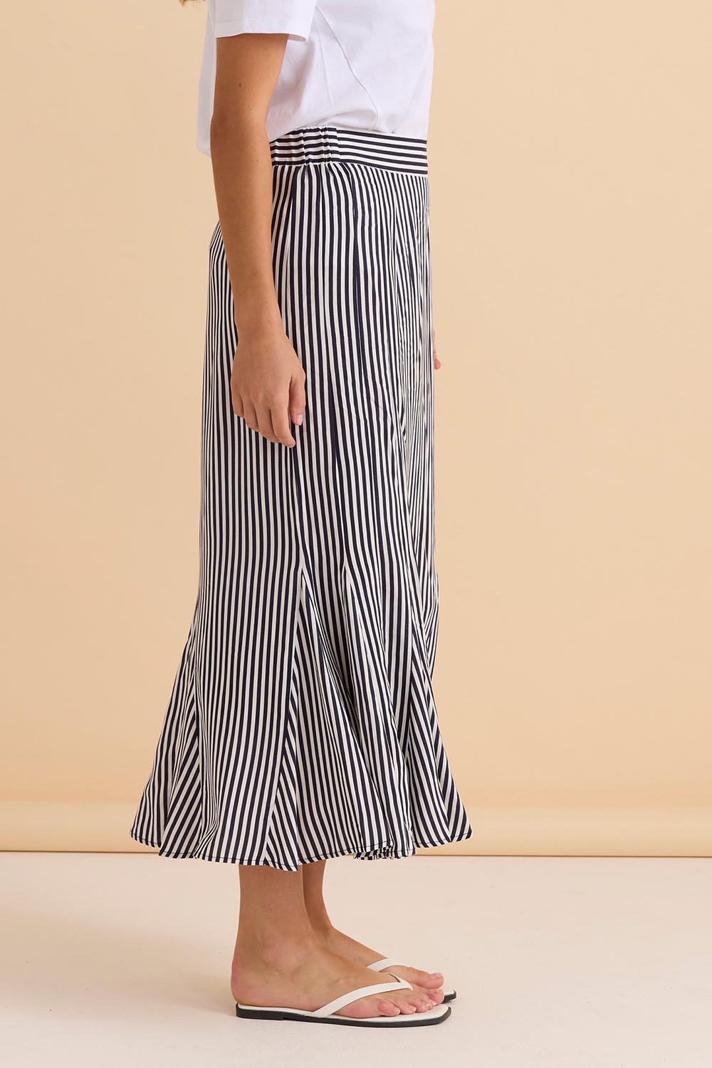 A model wearing the Darla Skirt in colour Navystripe (Blue), from the front, cropped image