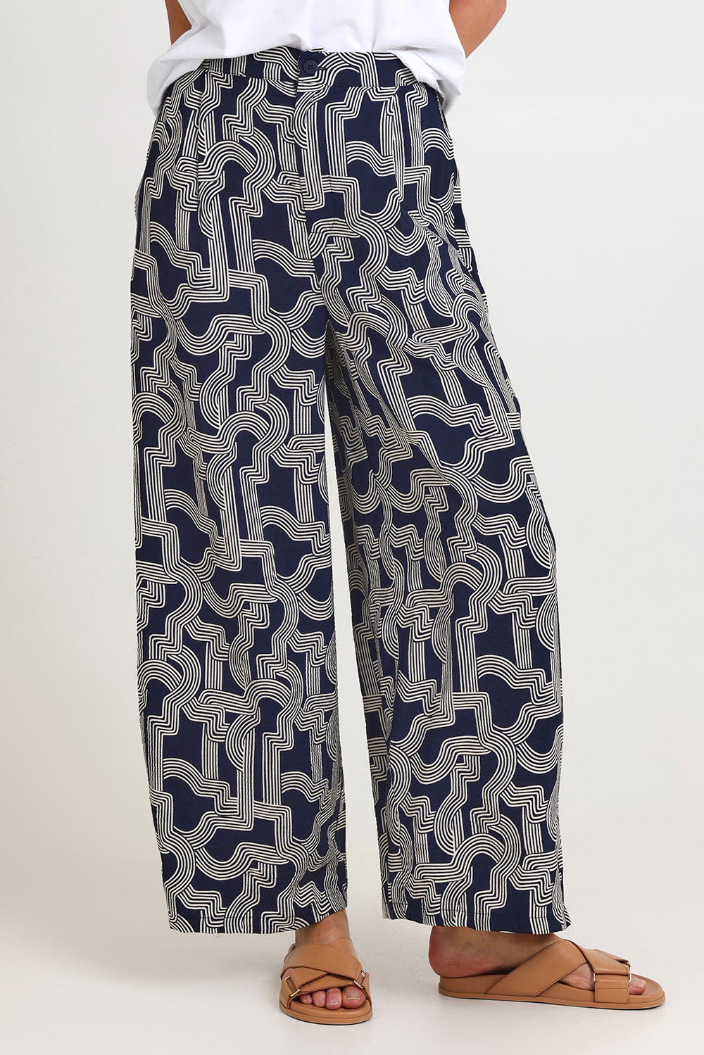 Model Madeline wearing size 10 of the Zander Pant in colour Navygeo (Blue), from the front, cropped image