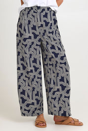 Model Madeline wearing size 10 of the Zander Pant in colour Navygeo (Blue), from the front, cropped image