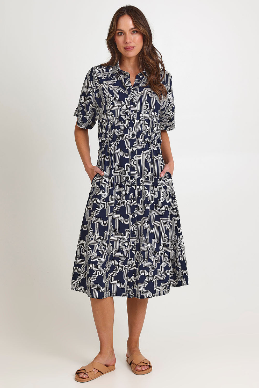 Model Madeline wearing size 10 of the Skye Dress in colour Navygeo (Blue), from the front, showing the whole outfit