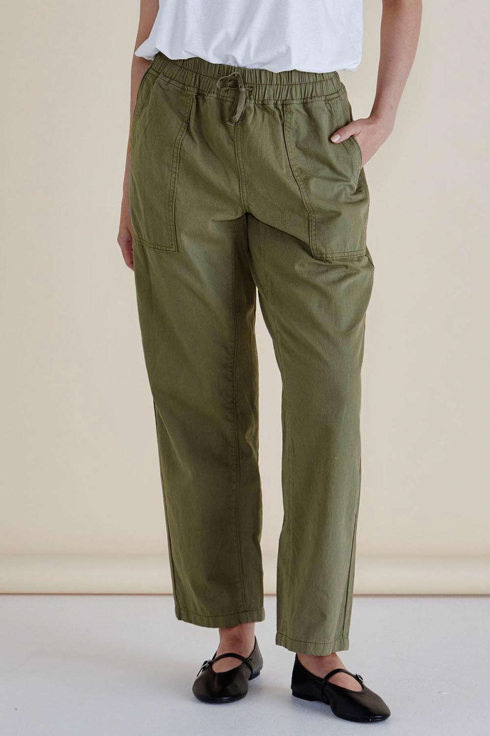 A model wearing the Quinn Cotton Jogger in colour Khaki (Green), from the front, cropped image