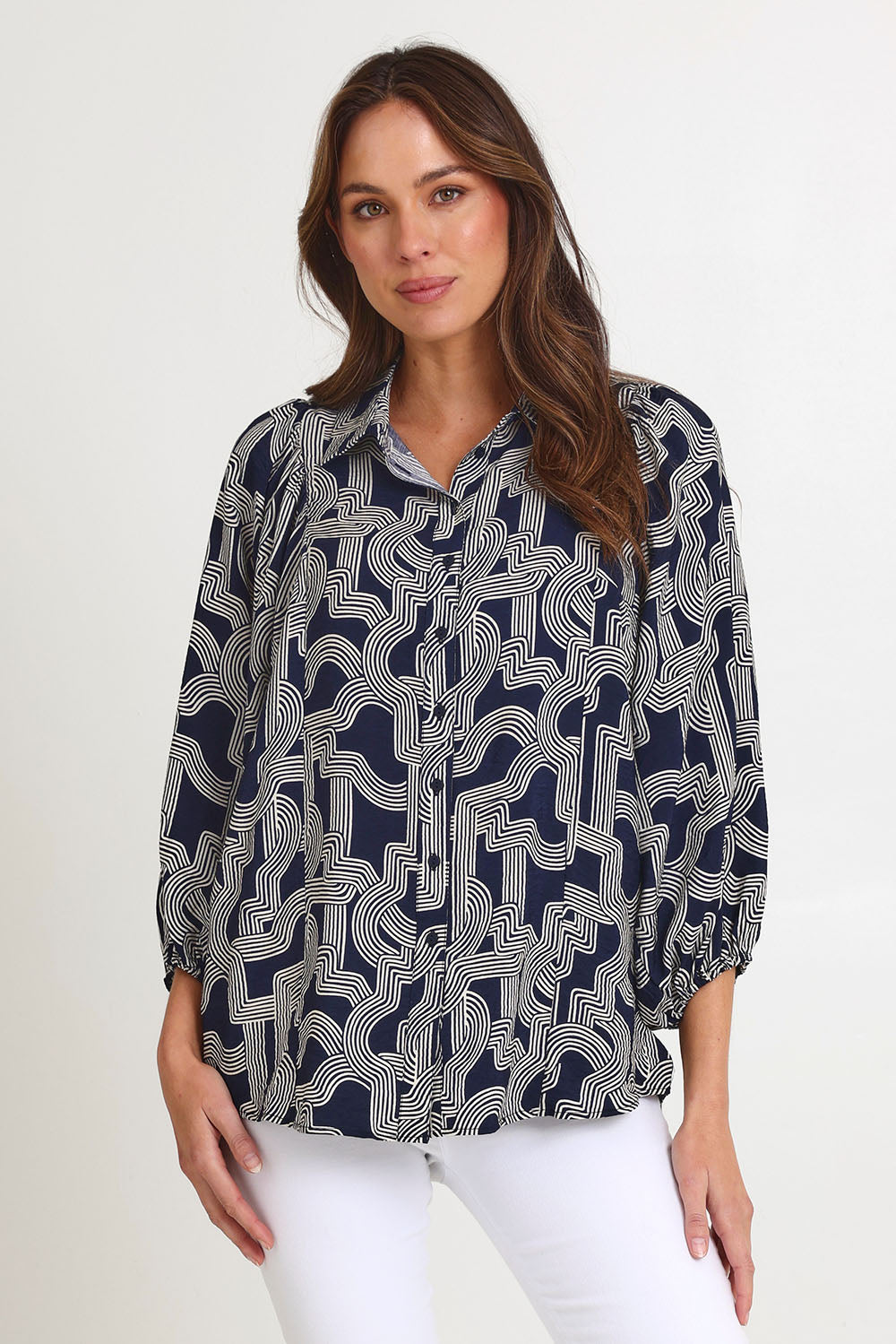 Model Madeline wearing size 10 of the Rosalind Shirt in colour Navygeo (Blue), from the front, cropped image