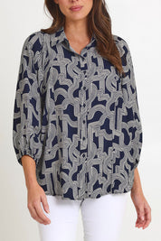 Model Madeline wearing size 10 of the Rosalind Shirt in colour Navygeo (Blue), from the front, cropped image