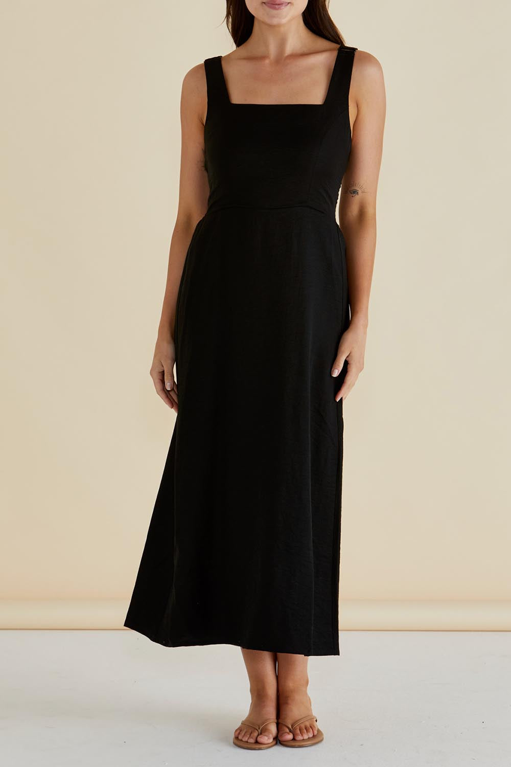 A model wearing the Tegan Midi Dress in colour Black (Black), from the front, cropped image