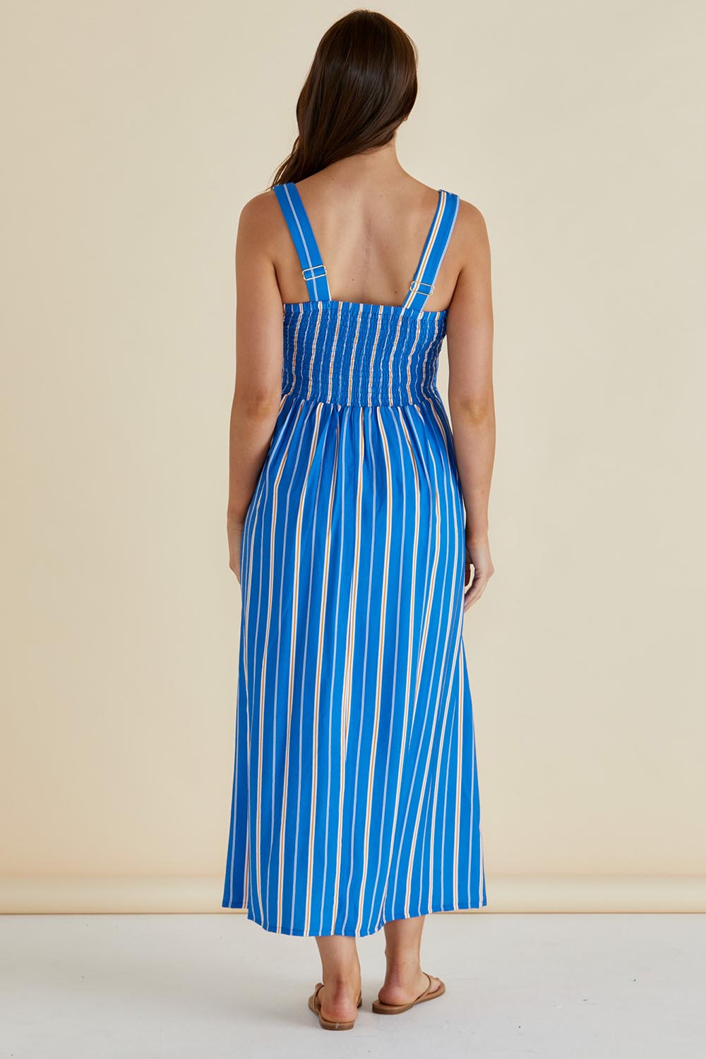 A model wearing the Tegan Midi Dress in colour Blue (Blue), from the back