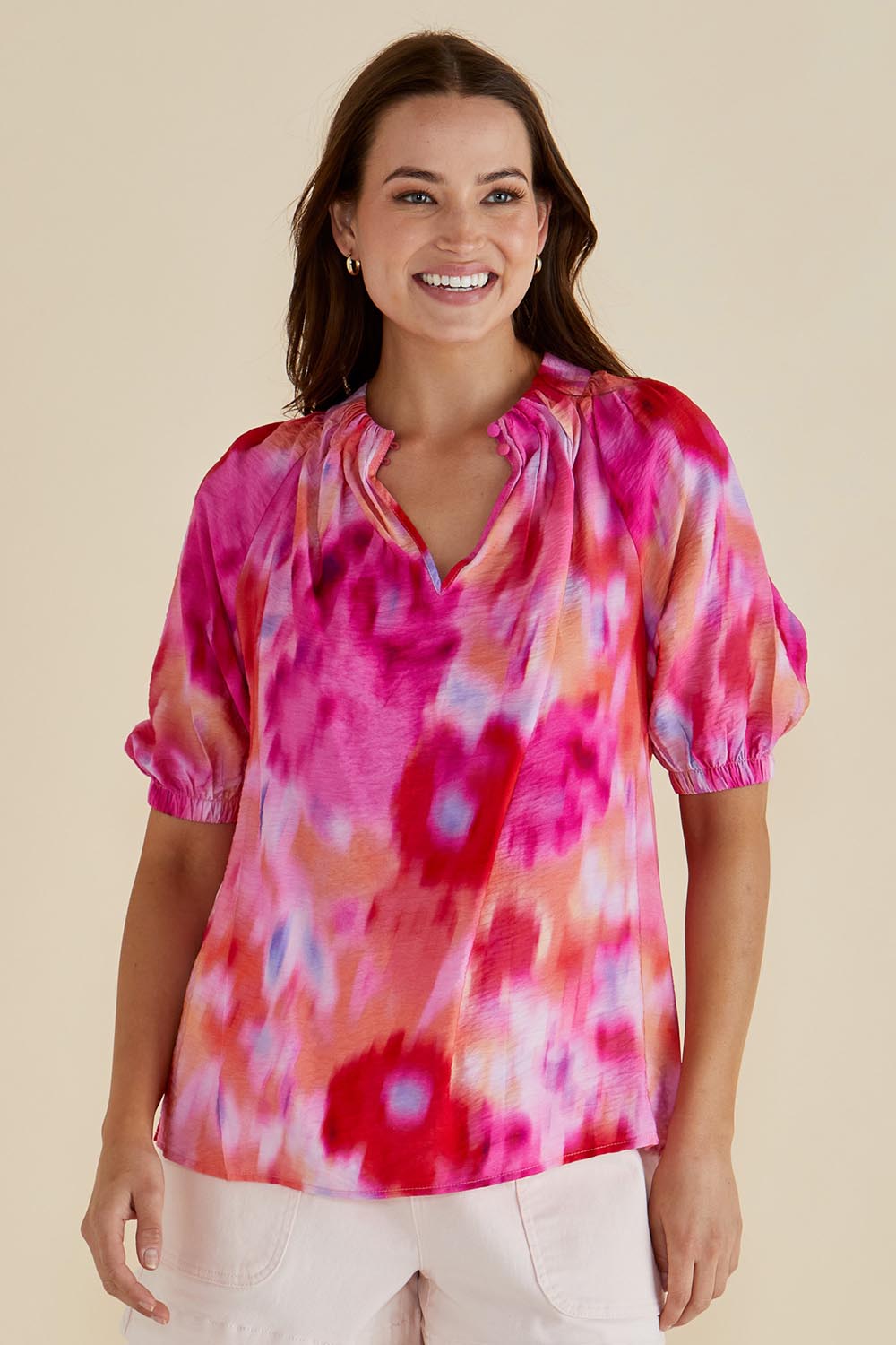 A model wearing the Joanne Blouse in colour Floral (Pink), from the front, cropped image