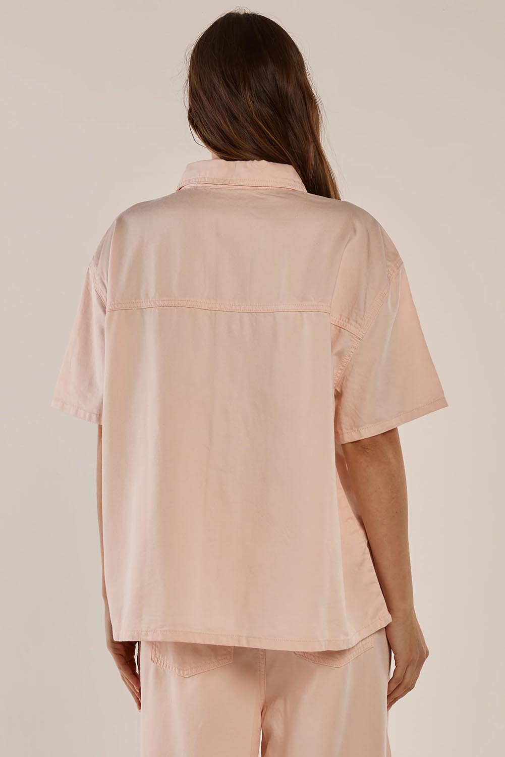 A model wearing the Saffra Short Sleeve Denim Shirt in colour Pink (Pink), from the back