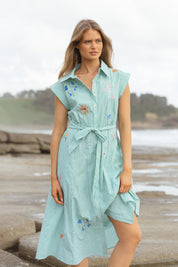 A model wearing the Gloria Floral Cotton Dress in colour Green (Green), from the front, showing the whole outfit
