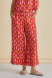A model wearing the Copacabana Relax Pant in colour Sardinia (Red), from the front, cropped image