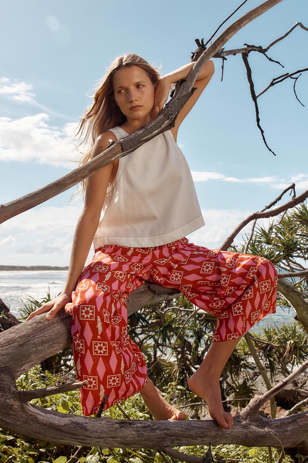 A model wearing the Copacabana Relax Pant in colour Sardinia (Red), from the front, showing the whole outfit