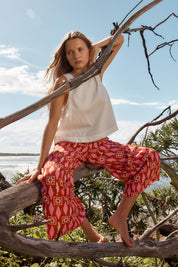 A model wearing the Copacabana Relax Pant in colour Sardinia (Red), from the front, showing the whole outfit