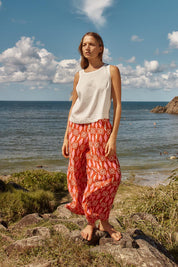 A model wearing the Copacabana Relax Pant in colour Sardinia (Red), from the front, showing the whole outfit