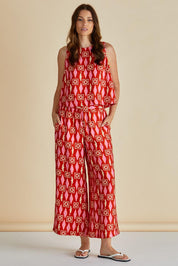 A model wearing the Copacabana Relax Pant in colour Sardinia (Red), from the front, showing the whole outfit