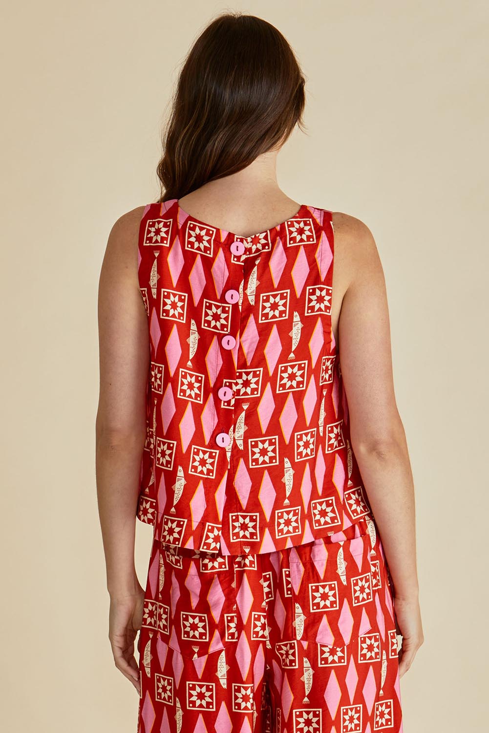 A model wearing the Copacabana Shell Top in colour Sardinia (Red), from the back