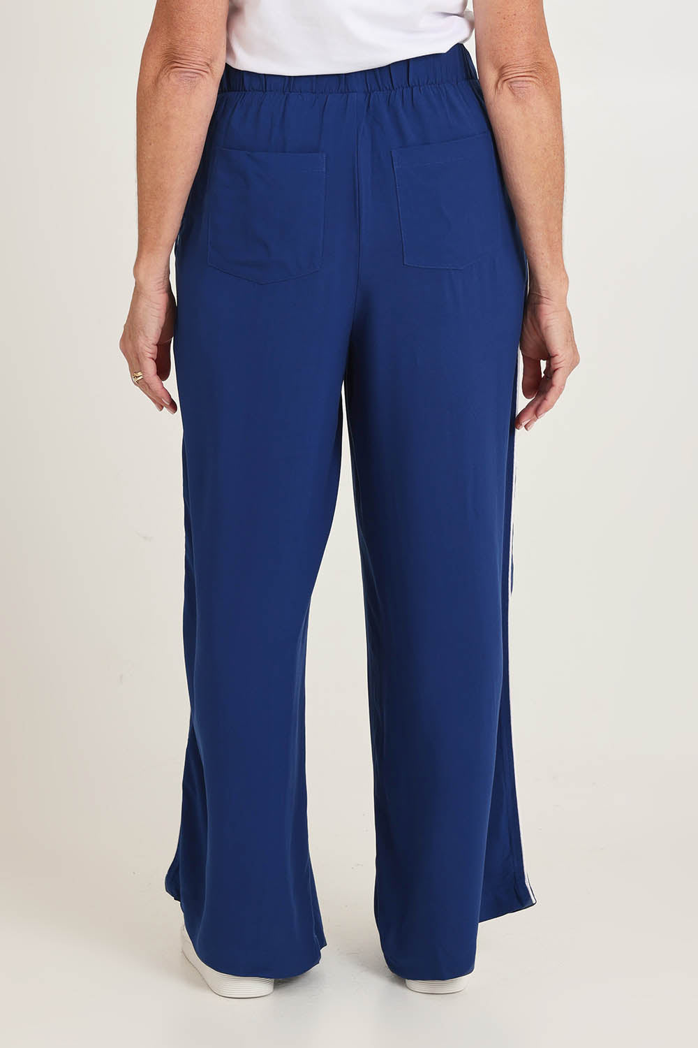 Model Sandy wearing size 10 of the Rio Reef Pant in colour Navy (Blue), from the back