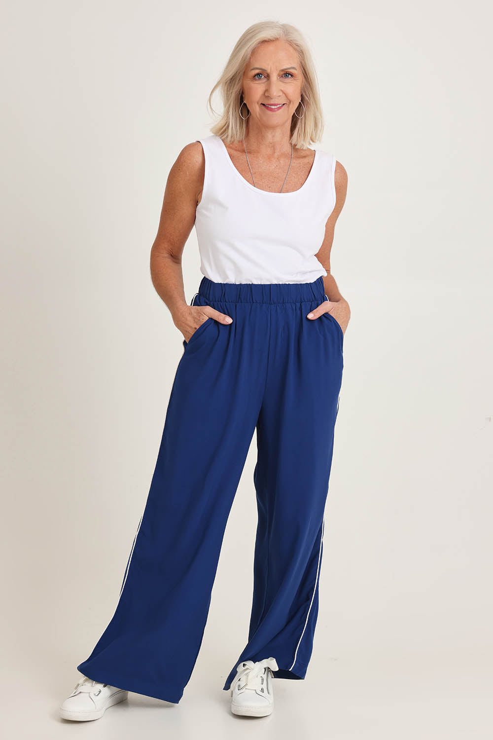 Model Sandy wearing size 10 of the Rio Reef Pant in colour Navy (Blue), from the front, showing the whole outfit