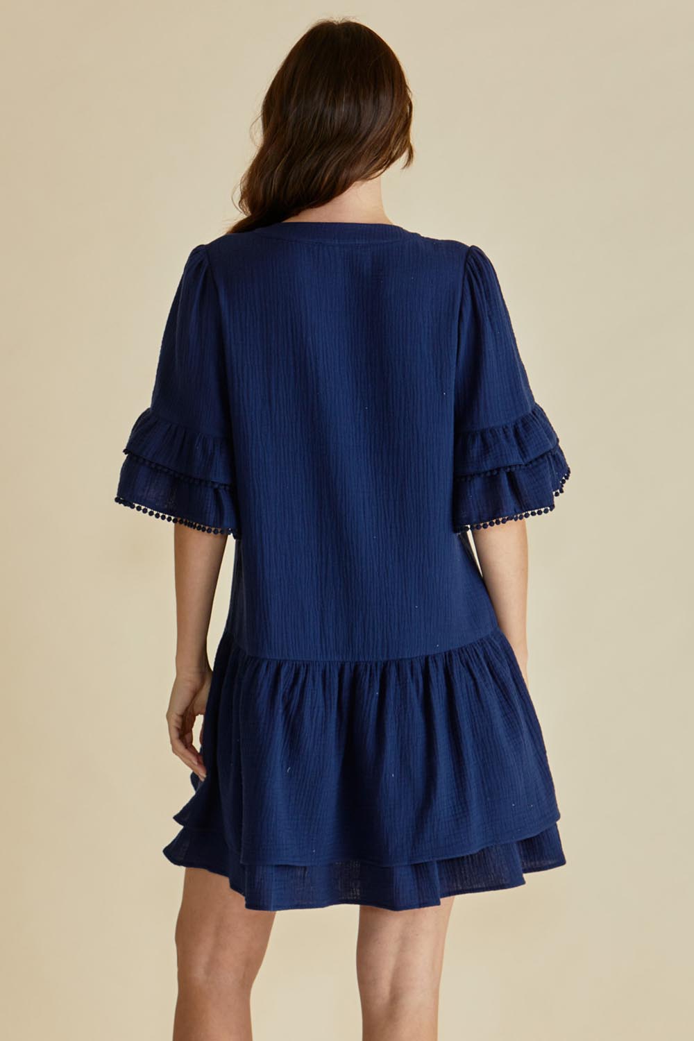 A model wearing the Malibu Cotton Dress in colour Navy (Blue), from the back
