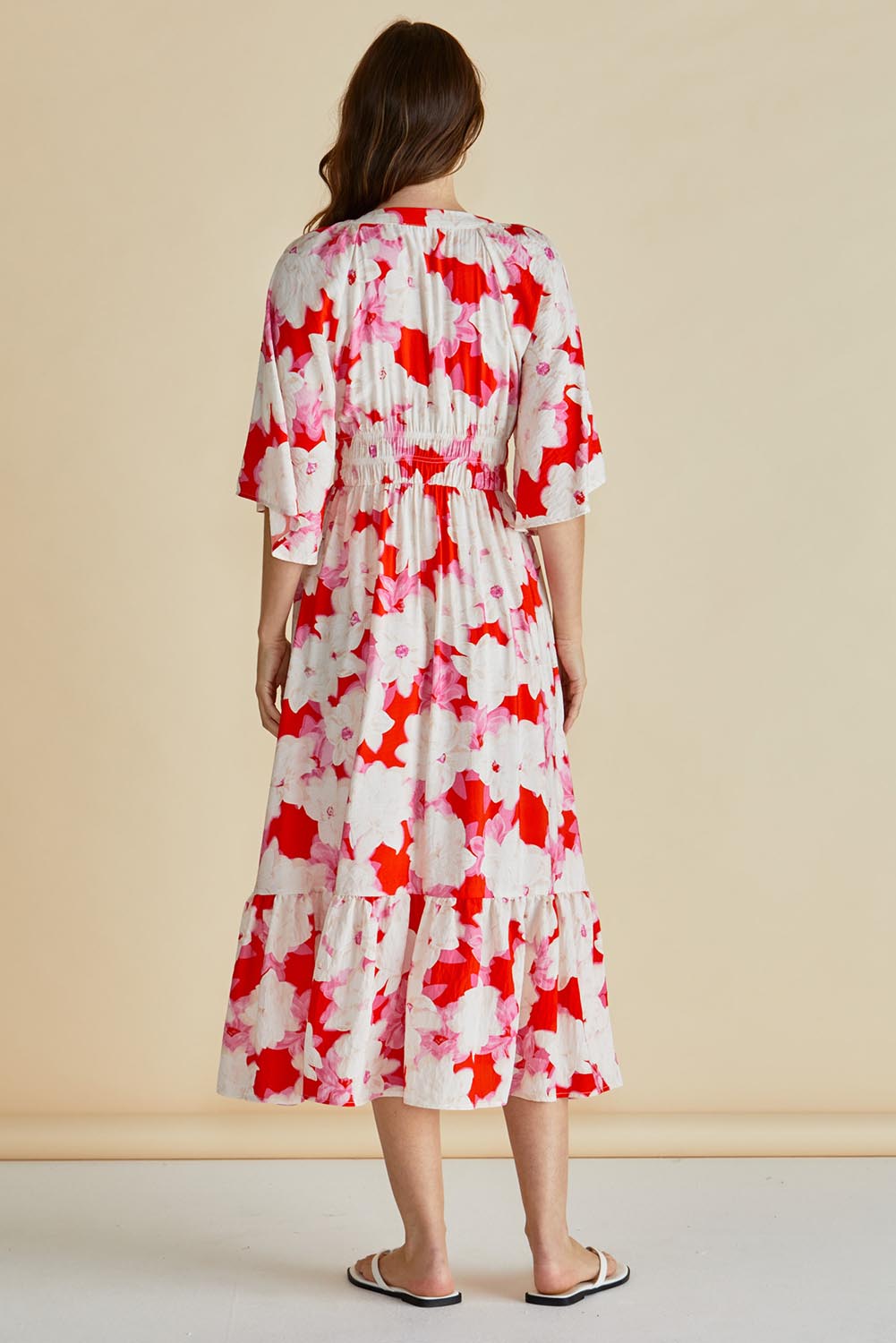 A model wearing the Moxie Dress in colour Redfloral (Red), from the back