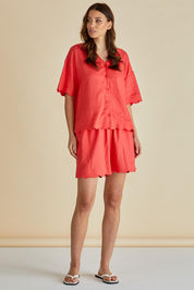 A model wearing the Scarlett Shirt in colour Red (Red), from the front, showing the whole outfit