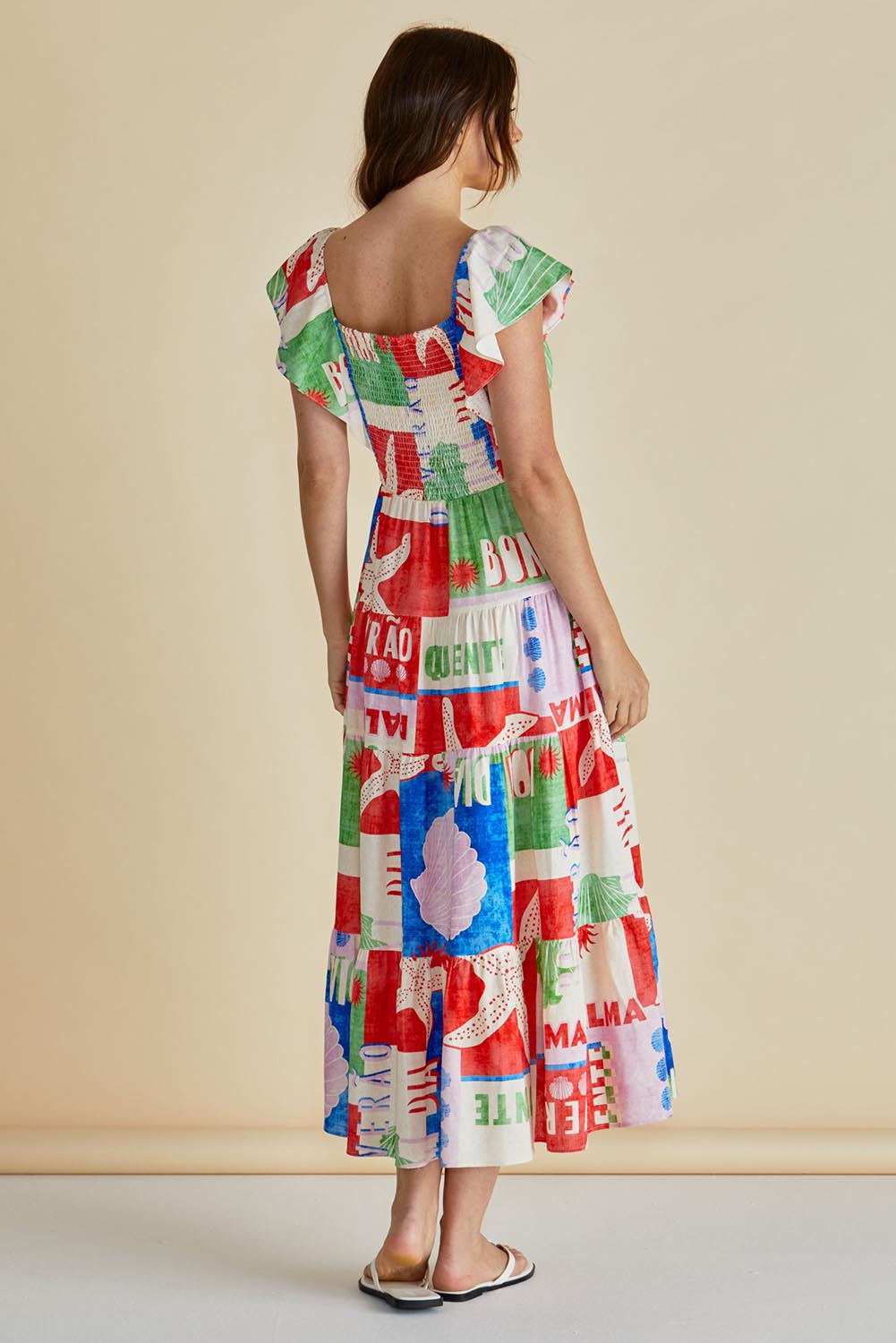A model wearing the Sadie Dress in colour Seashell, from the back