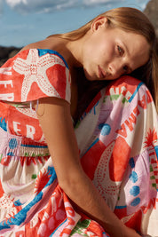 A model wearing the Sadie Dress in colour Seashell, from the front, showing the whole outfit