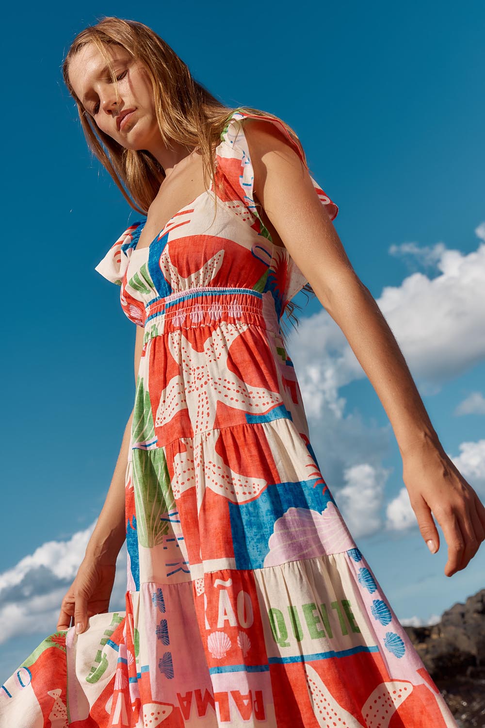 A model wearing the Sadie Dress in colour Seashell, from the front, showing the whole outfit