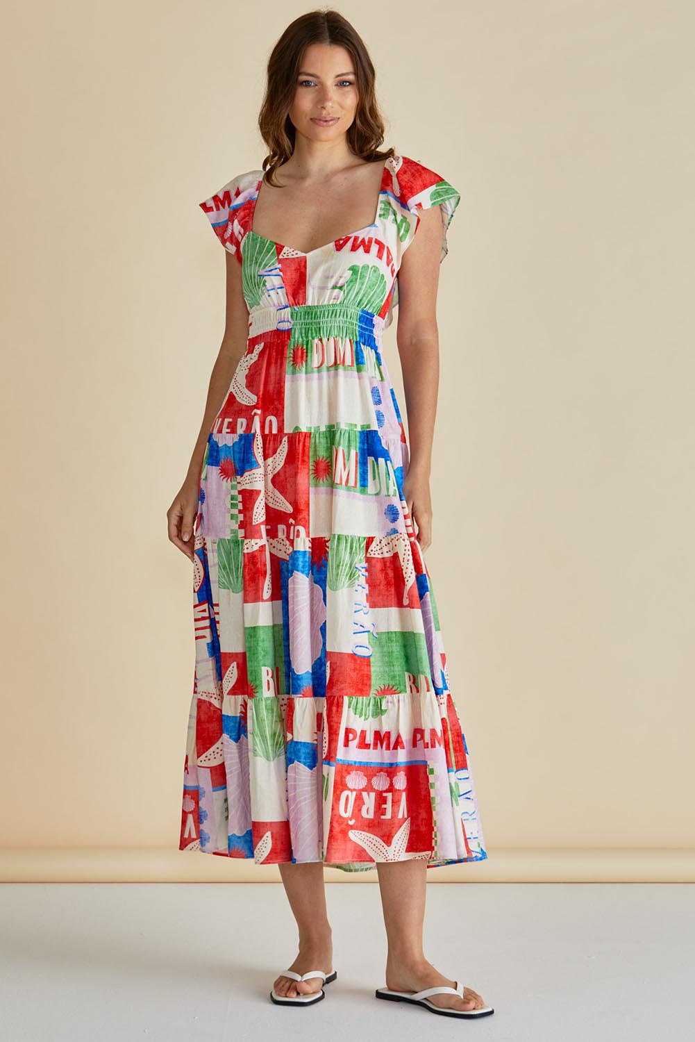A model wearing the Sadie Dress in colour Seashell, from the front, showing the whole outfit