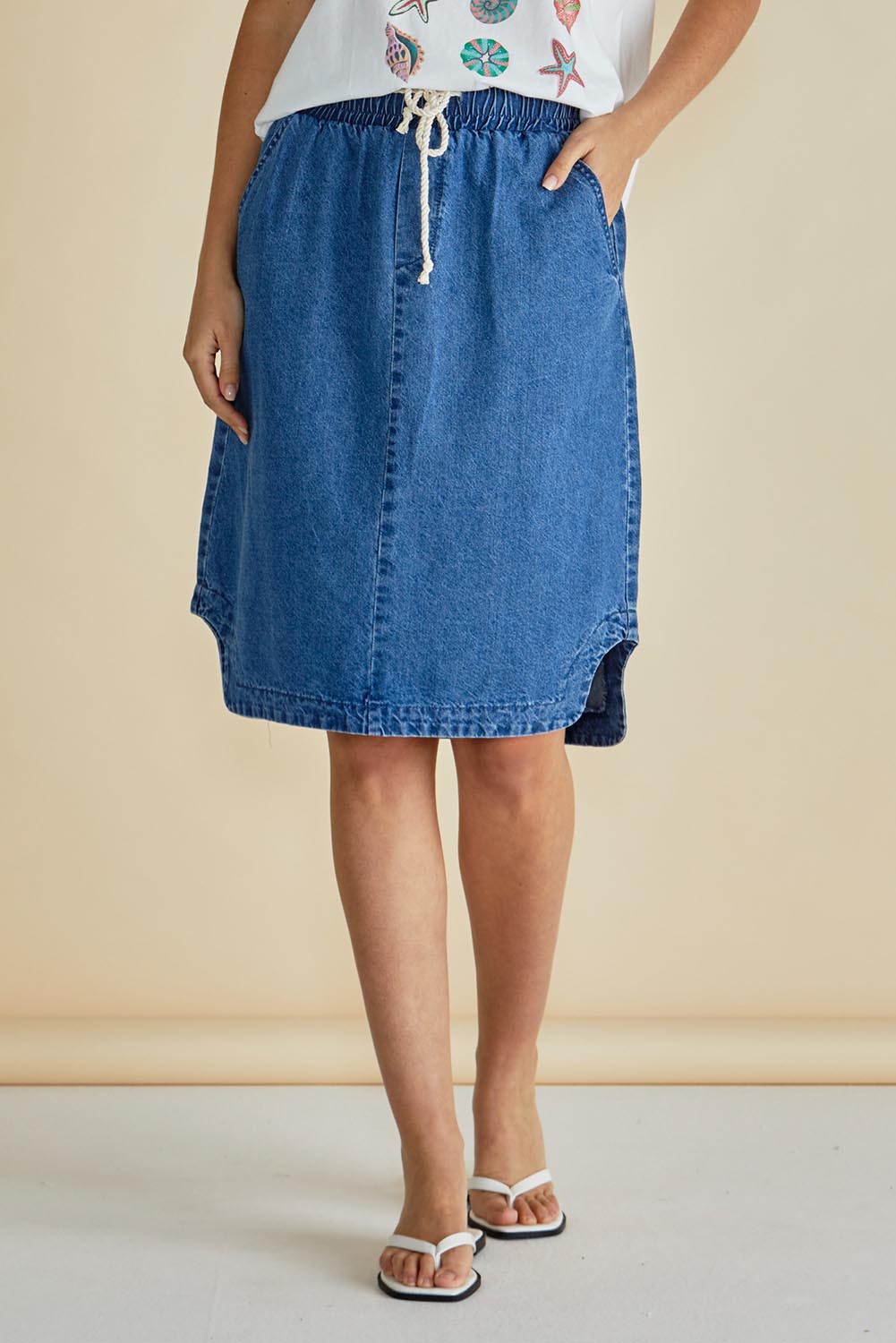 A model wearing the Dara Denim Skirt in colour Blue (Blue), from the front, cropped image